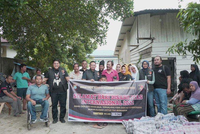 Kasubdit Jatanras Ditreskrimum Polda Riau AKBP Asep Sujarwadi didampingi Kanit Jatanras Kompol Indra Lamhot Sihombing dan anggota berfoto bersama penyandang disabailitas yang ada di Kecamatan Payung Sekaki, Kota Pekanbaru, Ahad (4/12/2022).